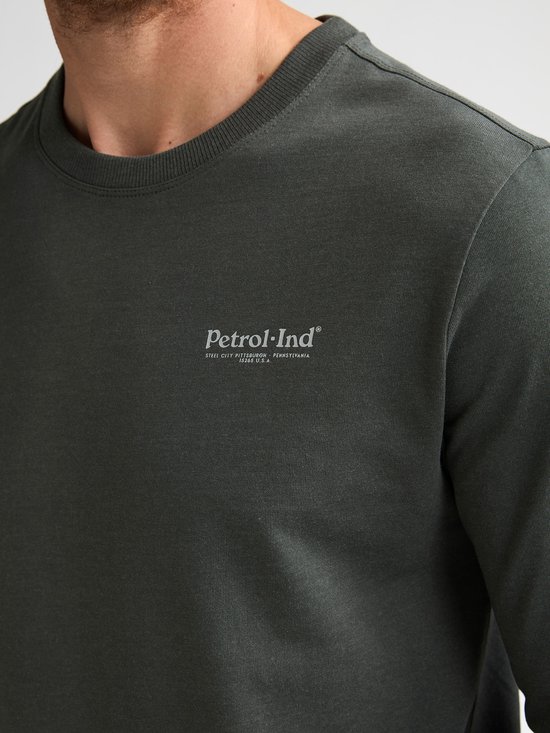 Close-up van een donkergroene longsleeve met opdruk 'Petrol Industries Steel City Pittsburgh Pennsylvania USA'.