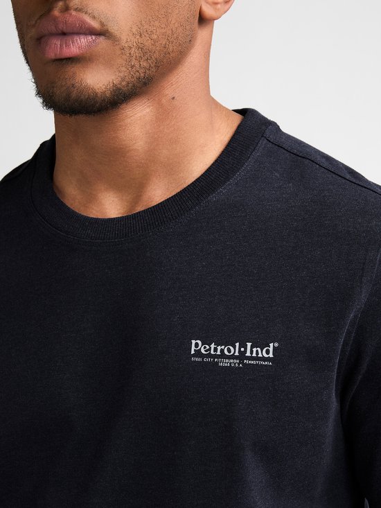 Close-up van donkerblauw longsleeve shirt met witte tekst: Petrol-Ind.