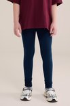 Onderlichaam van een meisje in donkerblauwe legging.