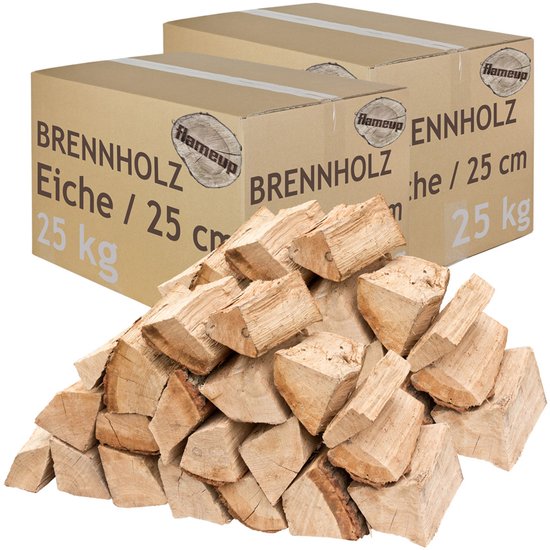 Twee kartonnen dozen met 25 kg eiken brandhout, elk 25 cm lang, met een stapel hout ervoor.