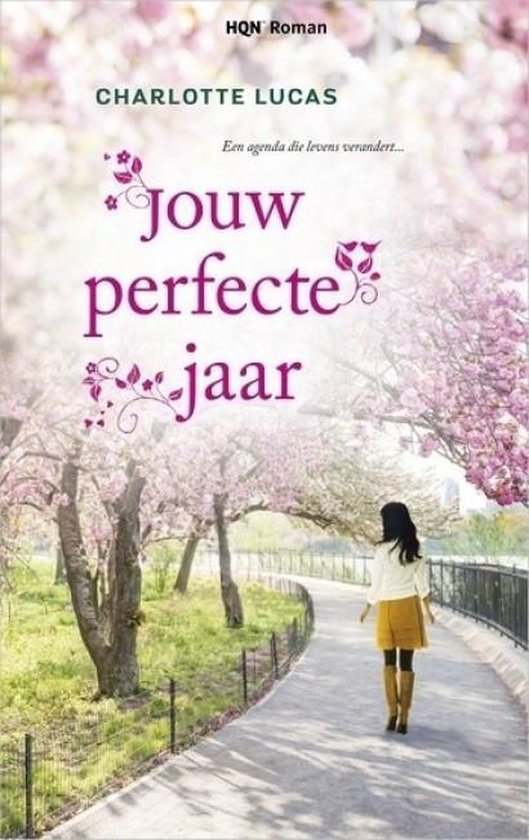 Boekcover met de titel 'Jouw perfecte jaar' door Charlotte Lucas, met een vrouw op een pad onder bloeiende bomen.