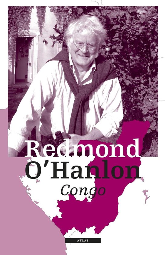 Een portret van Redmond O'Hanlon, een man met wit, warrig haar en een bril, lachend in een wit overhemd met een donker vest over zijn schouders.