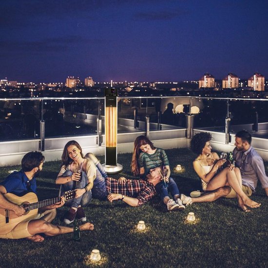 Groep vrienden op een dakterras met Trotec terrasverwarmer bij nacht, met lichtjes en stad op achtergrond.