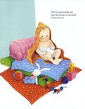 Baby met een gele handdoek met luipaardprint, zittend op kussens met speelgoed.