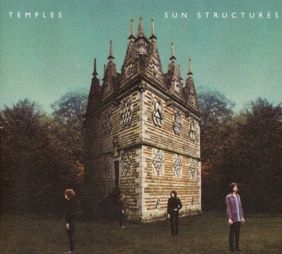 Vier mannen staan voor een stenen toren met puntige daken, omringd door bomen onder een groene hemel. Tekst: TEMPLES SUN STRUCTURES.