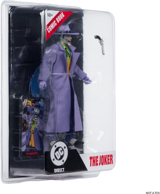 De Joker actiefiguur in verpakking, met paars pak, gele vest en paarse jas.
