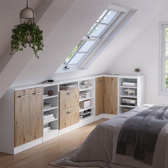 Witte opbergkasten met houten deuren en open vakken, onder een schuin dak, naast een bed.