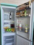 Turquoise Helvetia koel-vriescombinatie met open compartimenten.