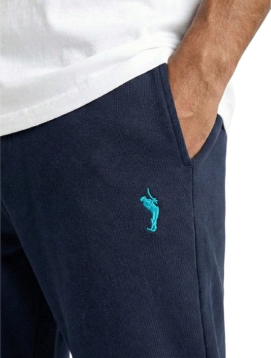 Detail van een navy joggingbroek met petrolblauw logo op de linkerheup.