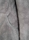 Gedetailleerd grijs fleece materiaal met een binnenzak.