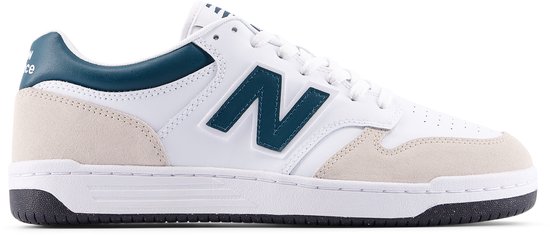Sneaker New Balance blanche avec accents en suède beige et logo N bleu foncé.
