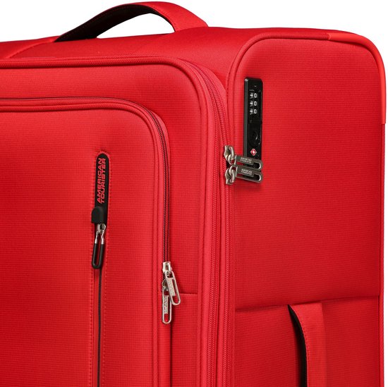 Detail van rode koffer met American Tourister logo, TSA-slot en ritstrekkers.