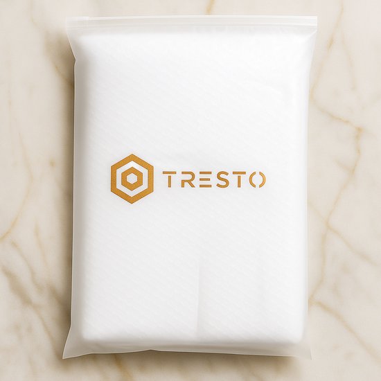 Witte verpakking met het Tresto logo in goudfolie erop gedrukt. De verpakking heeft een gestreept patroon en ligt op een marmeren ondergrond.