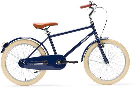 Vélo enfant bleu foncé avec selle marron et guidon marron, pneus et garde-boue crème.