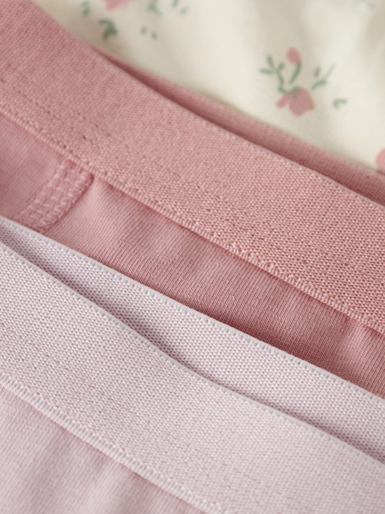 Close-up van de taillebanden van drie hipsters in roze tinten.