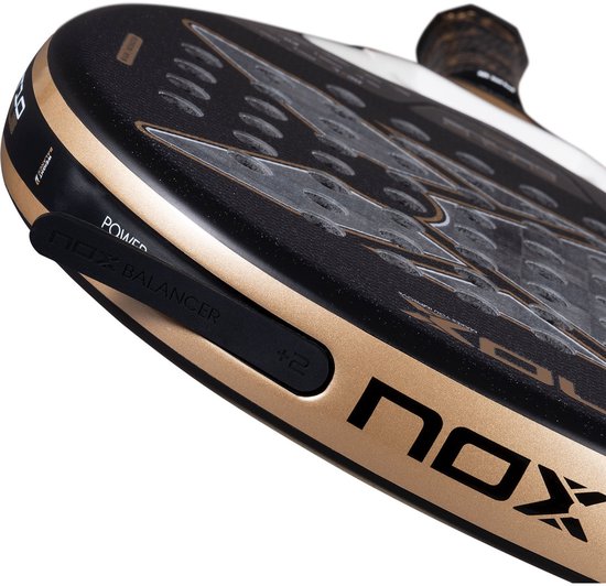 Zijkant van een zwarte padelracket met gouden rand, 'POWER' en 'NOX BALANCER'.