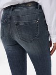 Achterkant van een donkerblauwe skinny jeans met middelhoge taille, lichte wassing en merklabel.