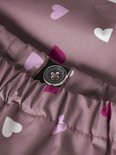 Detail van roze regenbroek met all-over hartjesprint en een knoopsluiting.