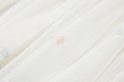 Roze bloemvormige applicatie op een off-white tule rok.