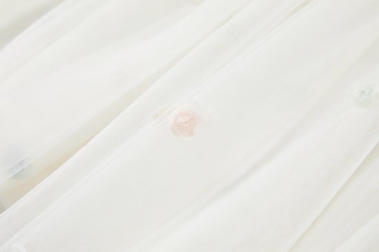 Roze bloemvormige applicatie op een off-white tule rok.