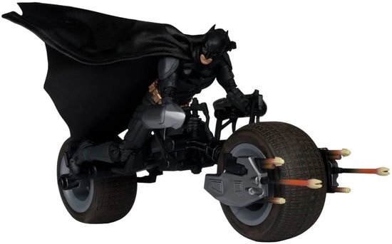 Batman op de Batpod, met de voorwielen en pinnen zichtbaar.