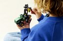 Jongen met LEGO Technic John Deere 1470H bosbouwmachine, groen, met werkende grijper.