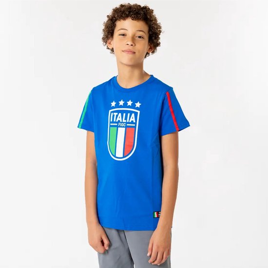 Jongen met krullend haar in een blauw T-shirt met Italiaanse voetbalembleem en strepen op de mouwen.