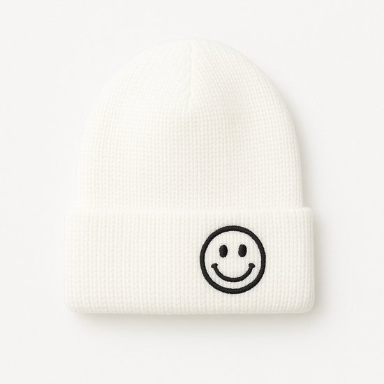 Witte gebreide muts met een zwarte smiley aan de voorkant.