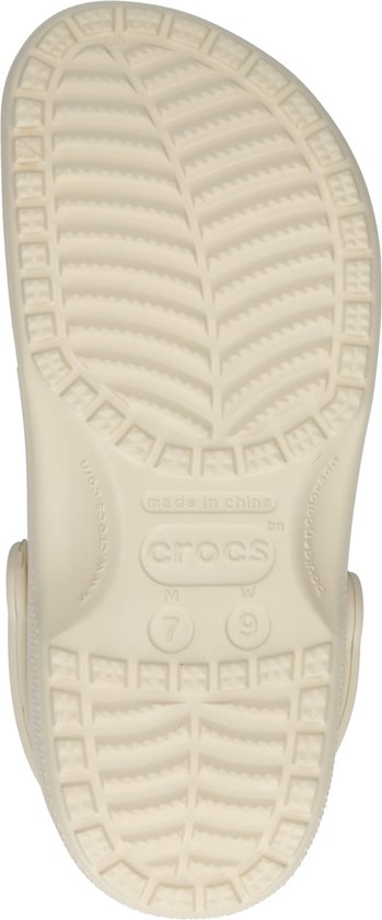 Crème Crocs, de onderkant toont de textuur en het maat 9 (W) logo.