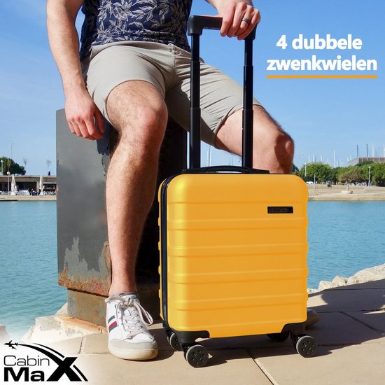 Man met zonnebril zit bij het water met een gele koffer. Met de tekst "4 dubbele zwenkwielen".