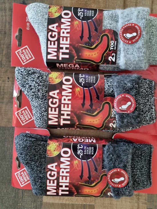 Drie paar Mega Thermo sokken in grijs en zwart, met label 'EXTRA LONG HAIR'. Op de verpakking staat 'MEGA THERMO -25°C KOUD'.