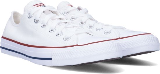 Paar witte lage Converse sneakers, met rode en blauwe strepen op de zool.