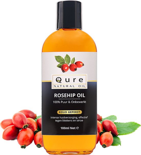 Fles Qure Rosehip Oil met een label waarop de tekst "ROSEHIP OIL 100% Puur & Onbewerkt KOUD GEPERST" staat. Rondom de fles liggen rozenbottels.