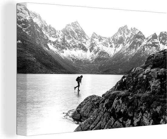 Canvas Schilderij Schaatser in een winters landschap met bergen – zwart wit – 60×40 cm – Wanddecoratie