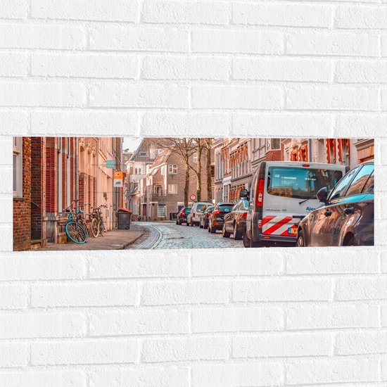 WallClassics - Muursticker - Geparkeerde Auto's in Stadje - 90x30 cm Foto op Muursticker