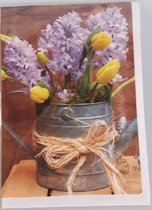 Een blanco kaart met een hyacint en tulpen in de gieter. Een leuke kaart om zo te geven of om bij een cadeau te voegen. Een dubbele wenskaart inclusief envelop en in folie verpakt.
