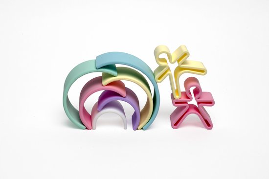 Pastelkleurige regenboogvormen en twee speelgoedfiguren in mensvorm, op een witte achtergrond.