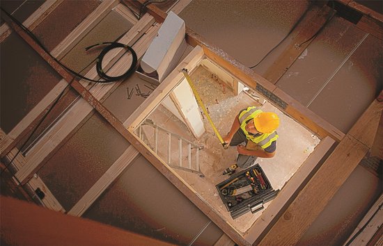 Man meet een opening met een Stanley meetlint in een woning in aanbouw.