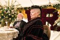 Koningin Victoria (Judi Dench) in een zwarte jurk met rode ruches, met een man op de achtergrond.