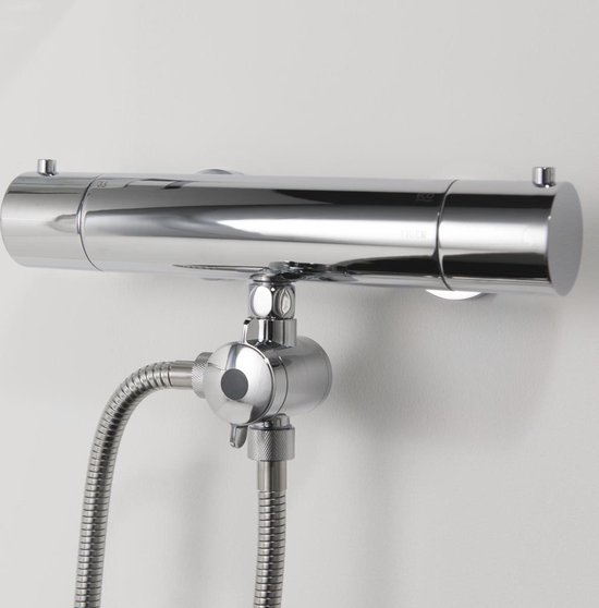 Chroomkleurige thermostaatkraan met ronde, donkergrijze omstelkraan, gemonteerd op een witte muur.