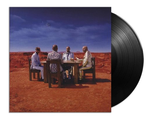 Een vinylplaat met de hoes van Muse's 'Black Holes & Revelations', waarop vier mannen aan een tafel in een woestijnlandschap zitten.