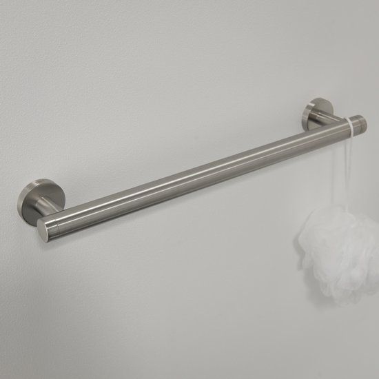 Geborstelde RVS handgreep aan een witte muur met een witte douchetrekker eraan.