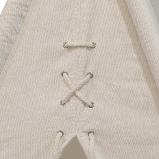 Detail van de sluiting van een crèmekleurige katoenen tipi tent met zichtbare stiksels en touwen.