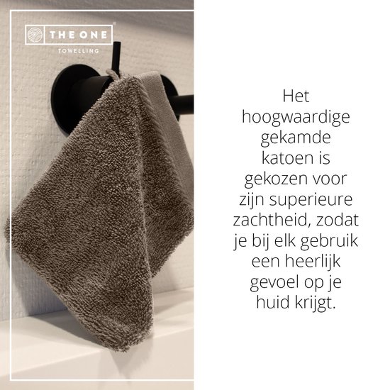Een taupe washandje van hoogwaardig gekamd katoen hangt aan een zwarte houder.
