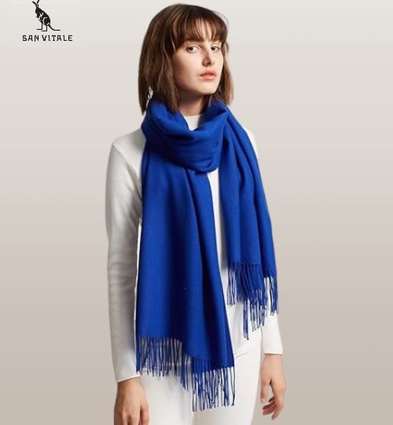 Model met koningsblauwe pashminasjaal met franjes, gedragen met een witte coltrui.