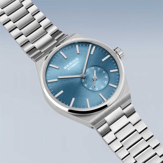 Zilverkleurig horloge met blauwe wijzerplaat en zilverkleurige band. BERING AUTOMATIC.