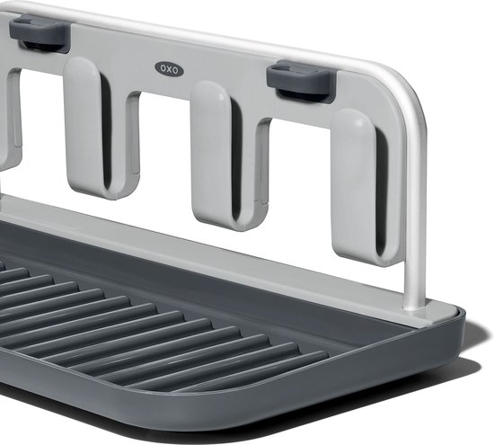 Gros plan d'un égouttoir gris foncé avec une grille et un plateau amovible.