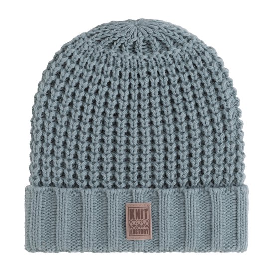 Lichtgroene, grof gebreide muts van Knit Factory met omslag en bruin logo-label.
