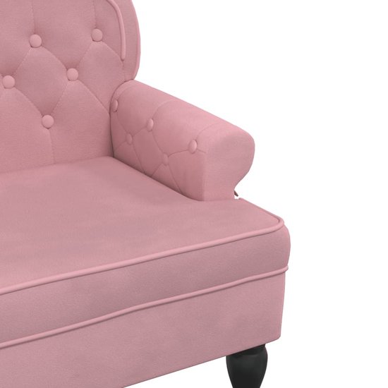 Roze fluwelen bankje met knopen en zwarte pootjes.