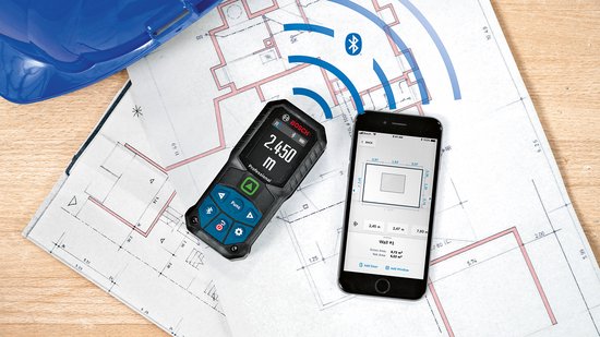 Bosch laser afstandmeter en smartphone op bouwplannen. Beiden tonen meetgegevens en verbinding via Bluetooth.